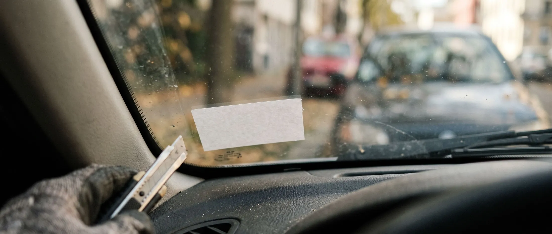 The lower corner of a car windscreen where the inspection sticker sits