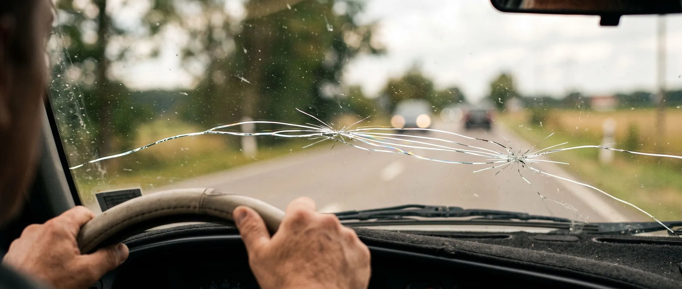 A long crack running across a car windscreen seen from inside the cabin